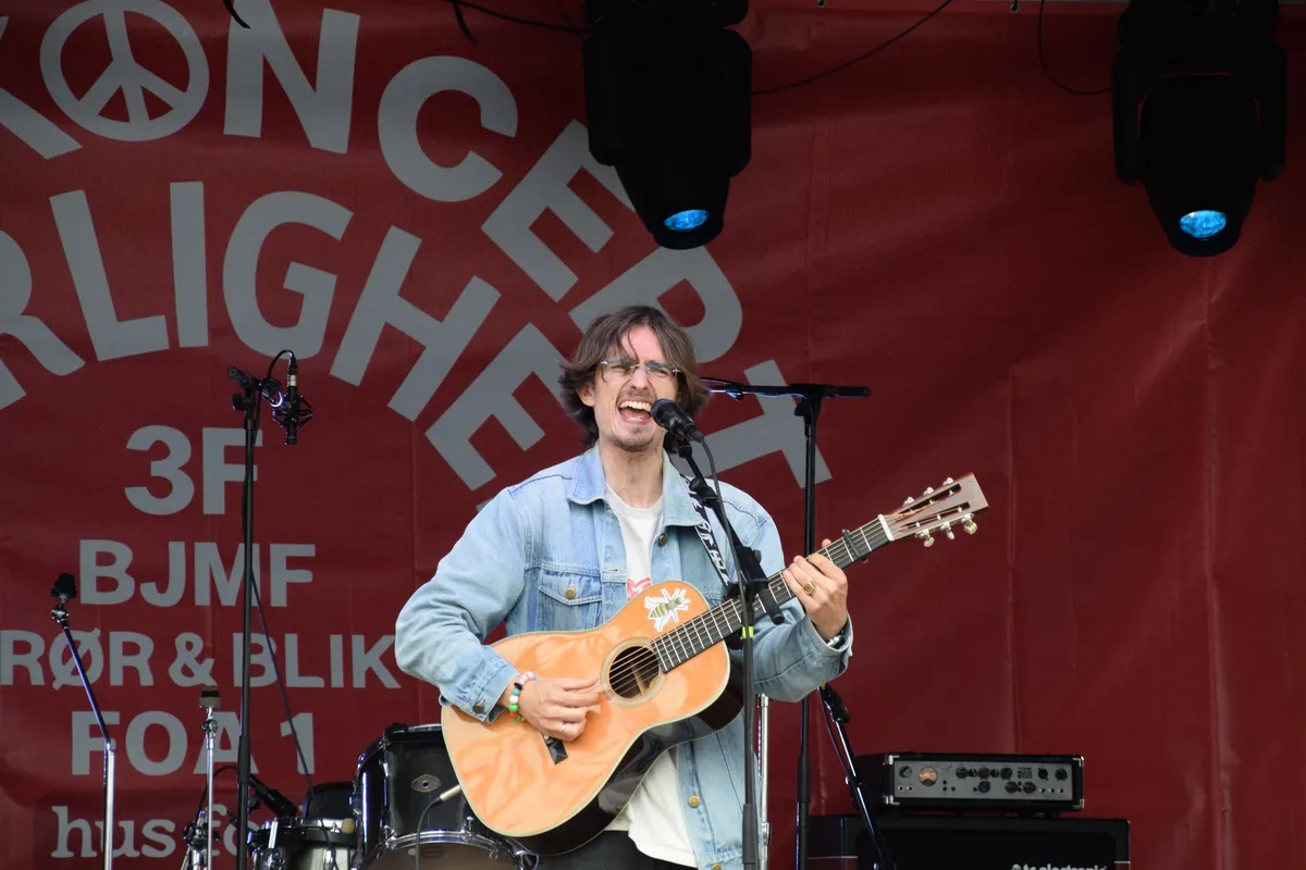 Jonas Mačys smiler og synger på scenen