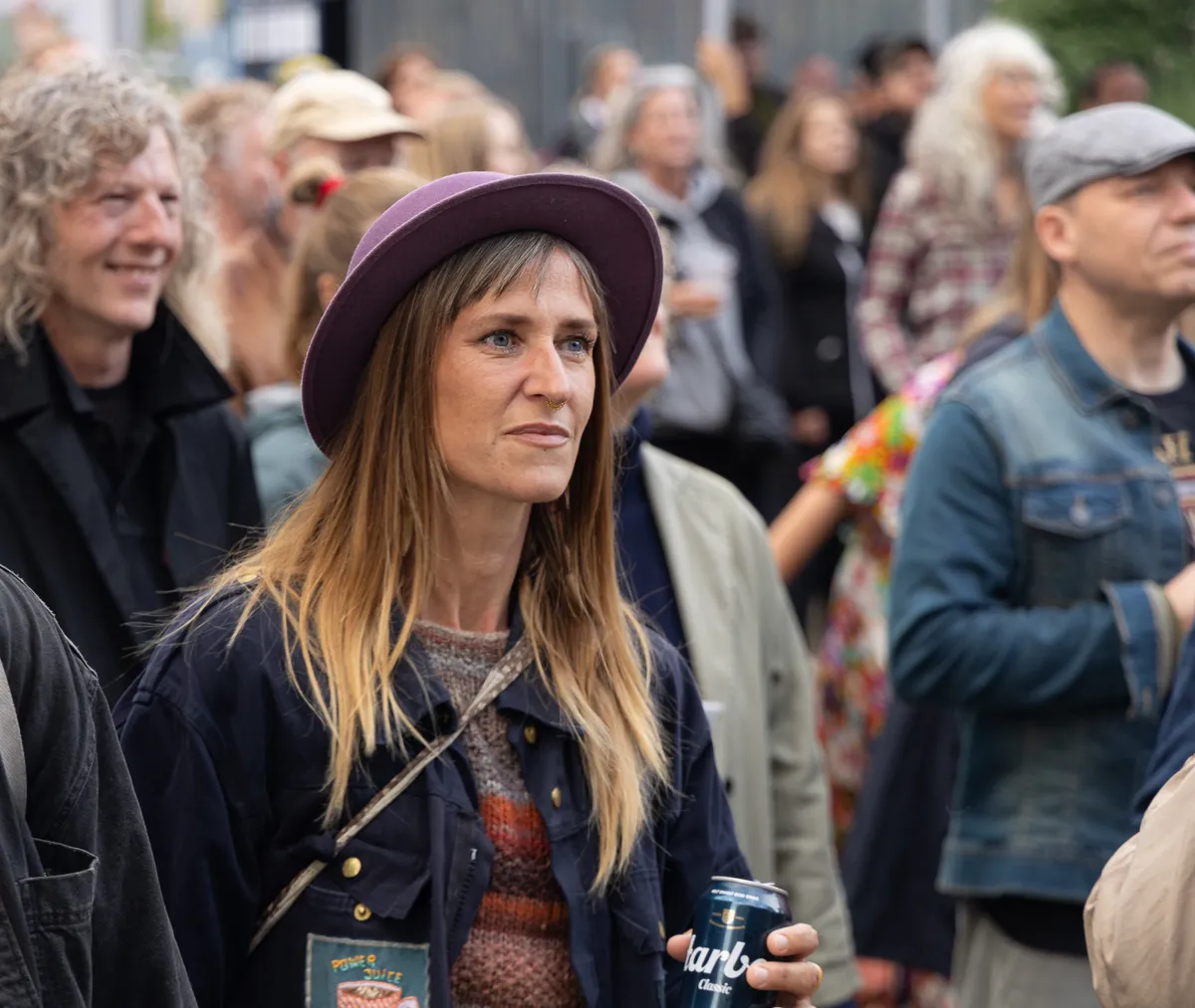 Kvinde med hat lytter til musikken i publikum