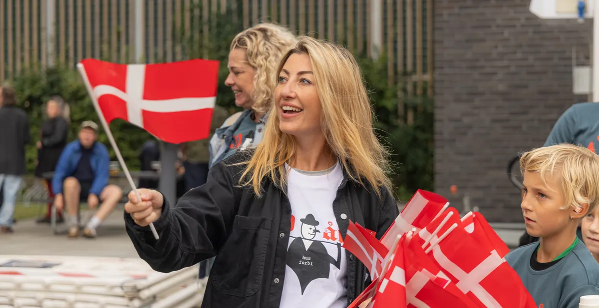 Kvinde med Dannebrogsflag og flere flag i armene