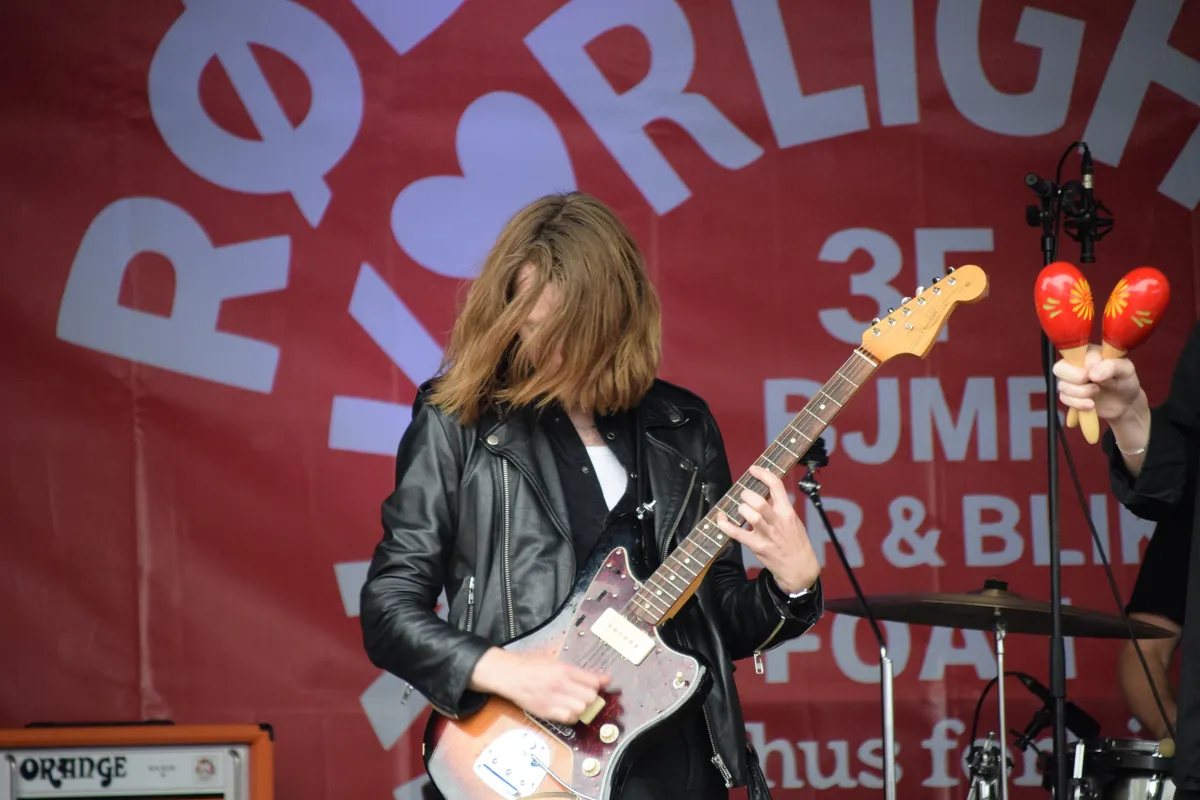 Guitarist med maracas i baggrunden til The Deadly Sons koncert