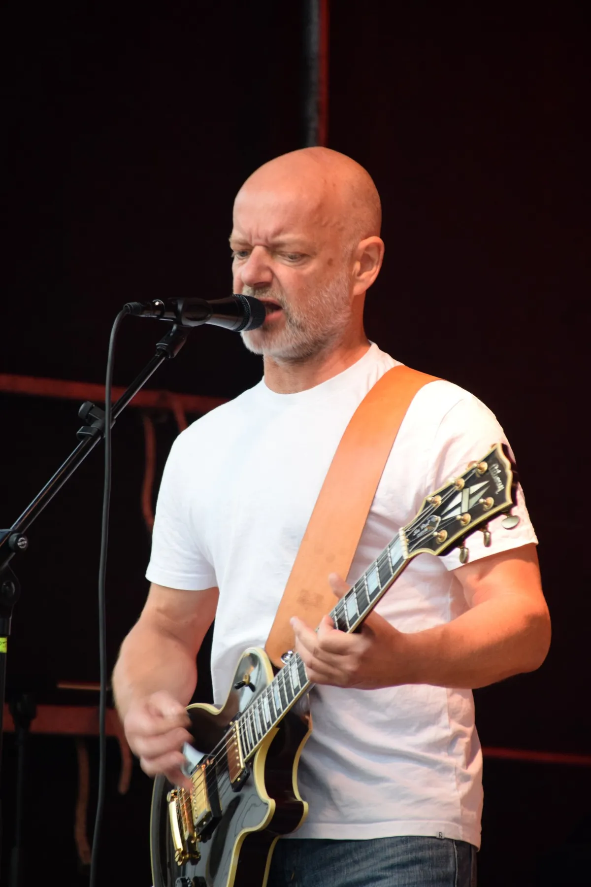 Zeups guitarist synger i mikrofonen i hvid T-shirt